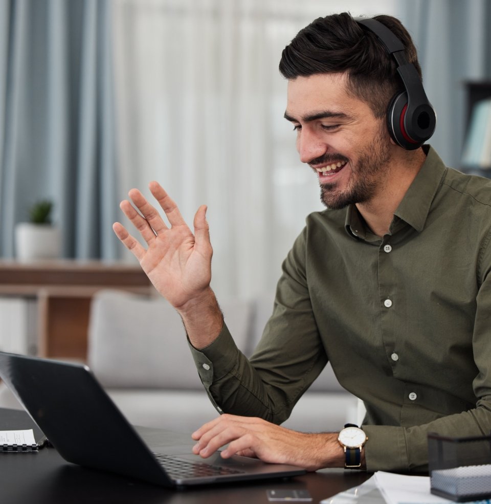 man in online meeting wearing headset and smiling